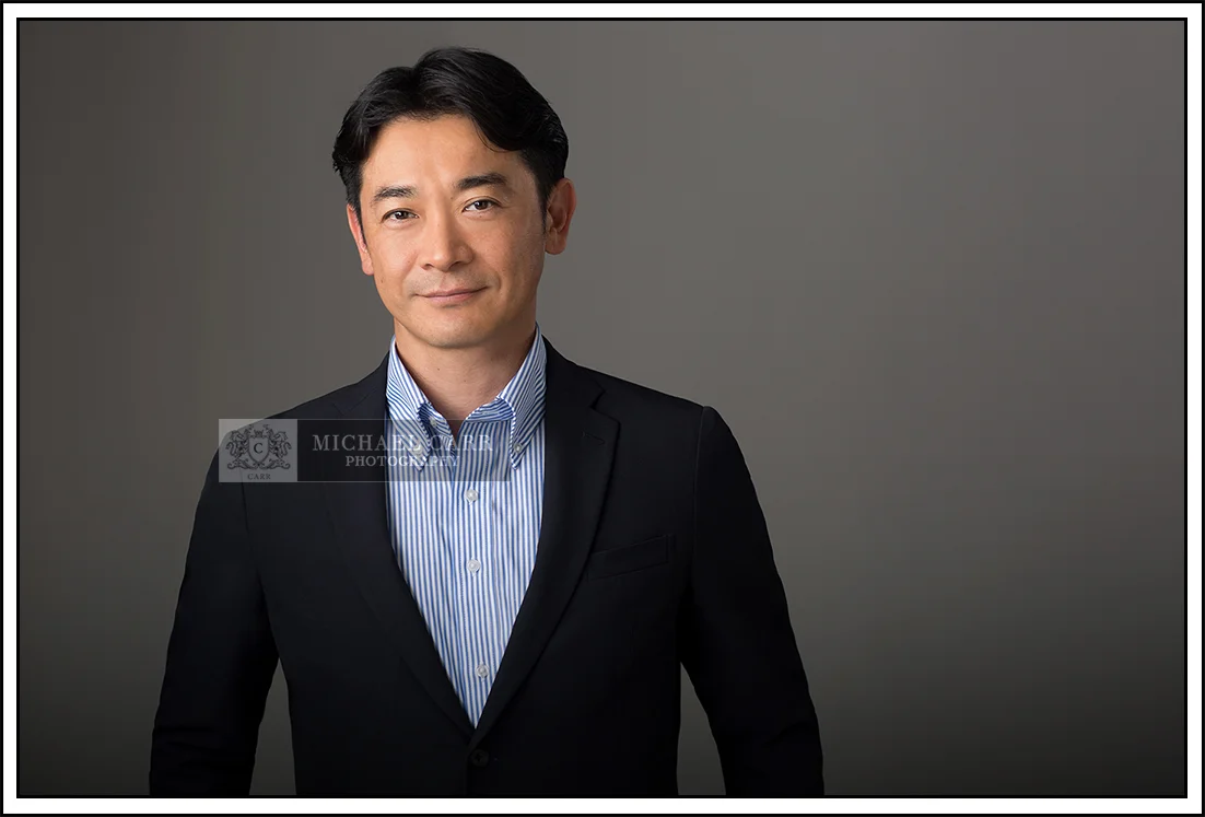 Professional Photographer Houston Houston modern casual headshot of a business professional wearing a blue blazer and open-collar white shirt