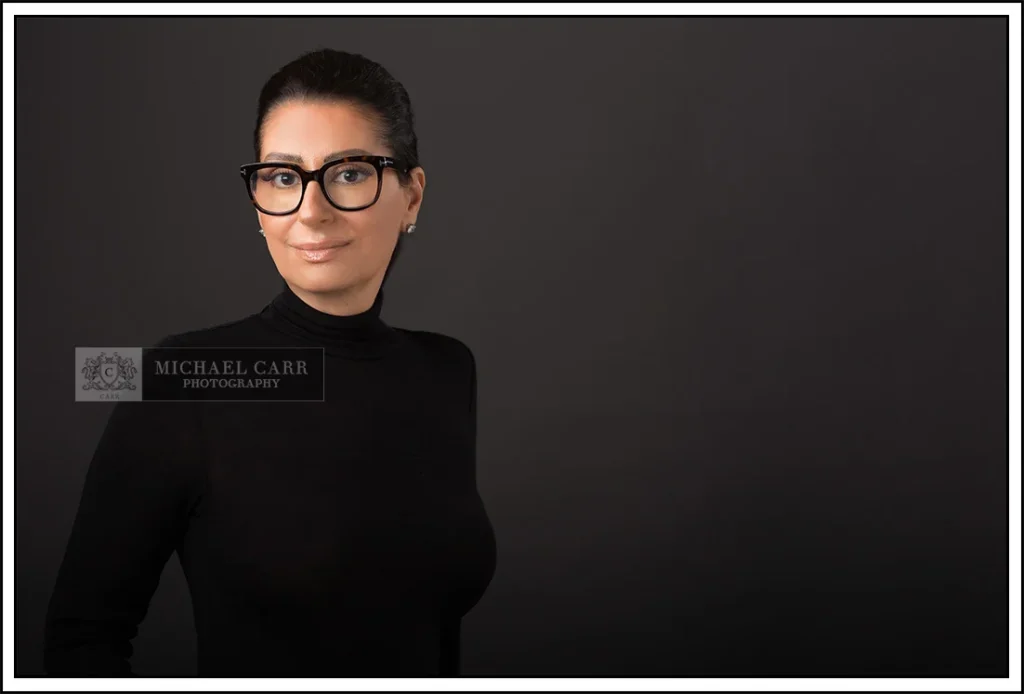 Professional Photographer Houston Houston modern casual headshot of a business professional wearing a black turtleneck sweater and glasses