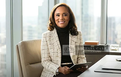 Professional Photographer Houston Businesswoman seated in a modern office during a Houston personal branding photography session.
