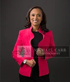 Professional Photographer Houston Studio portrait of a businesswoman wearing a pink blazer during a Houston personal branding photography session.